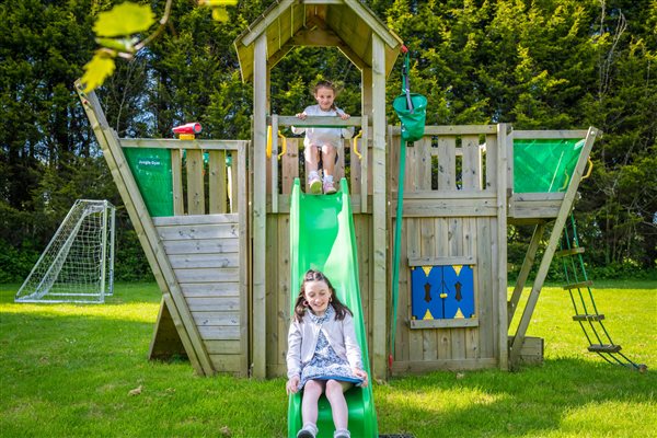 Children playing on climbing frame and slide.